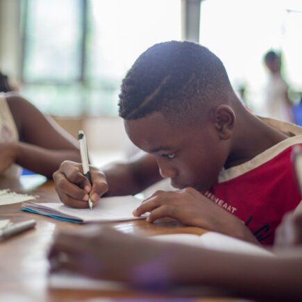 boy writing on printer paper near girl